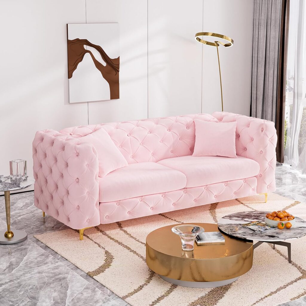 Pink velvet tufted Chesterfield sofa with gold metal legs and matching throw pillows