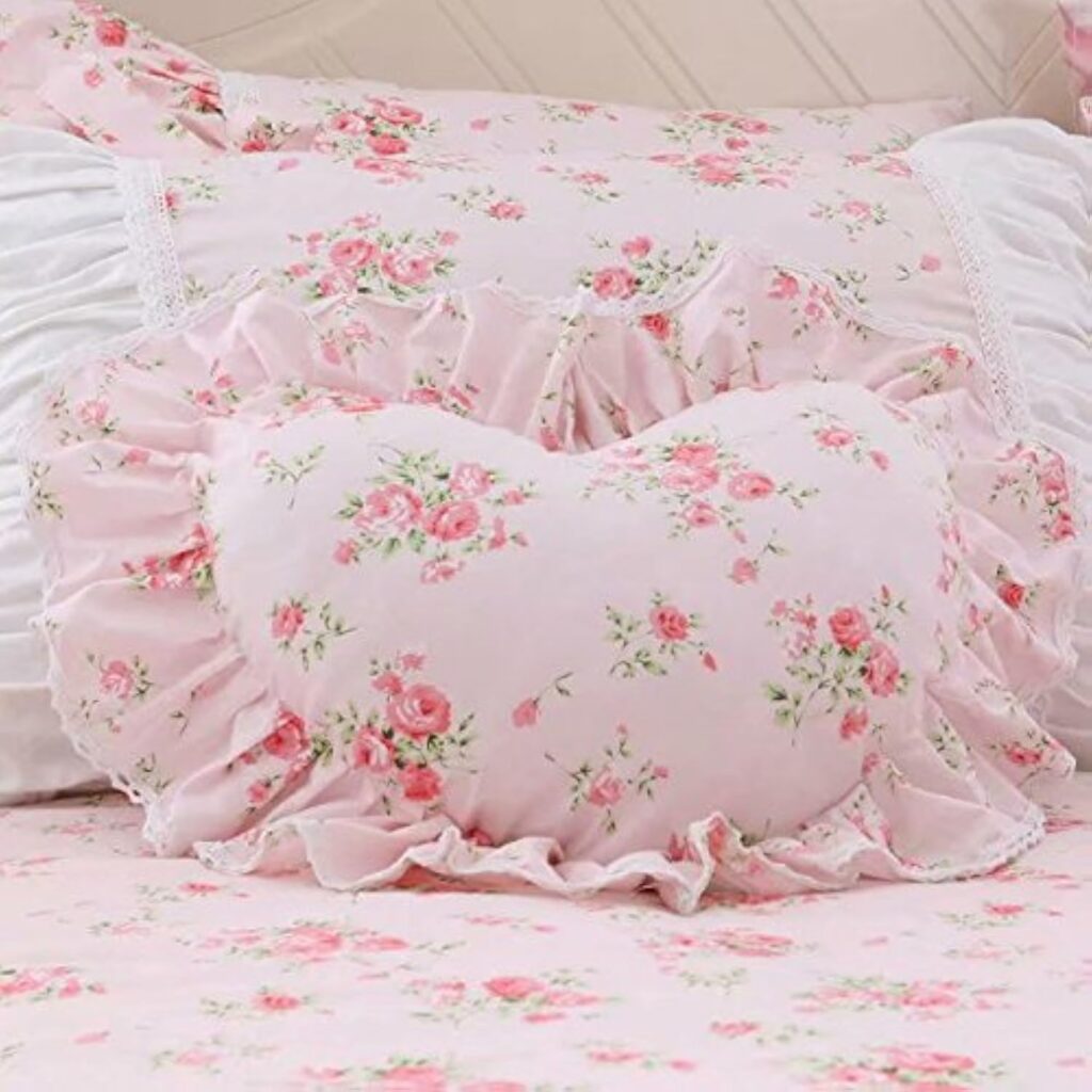 Pink heart-shaped throw pillow with lace ruffle trim and soft floral-inspired decorative design