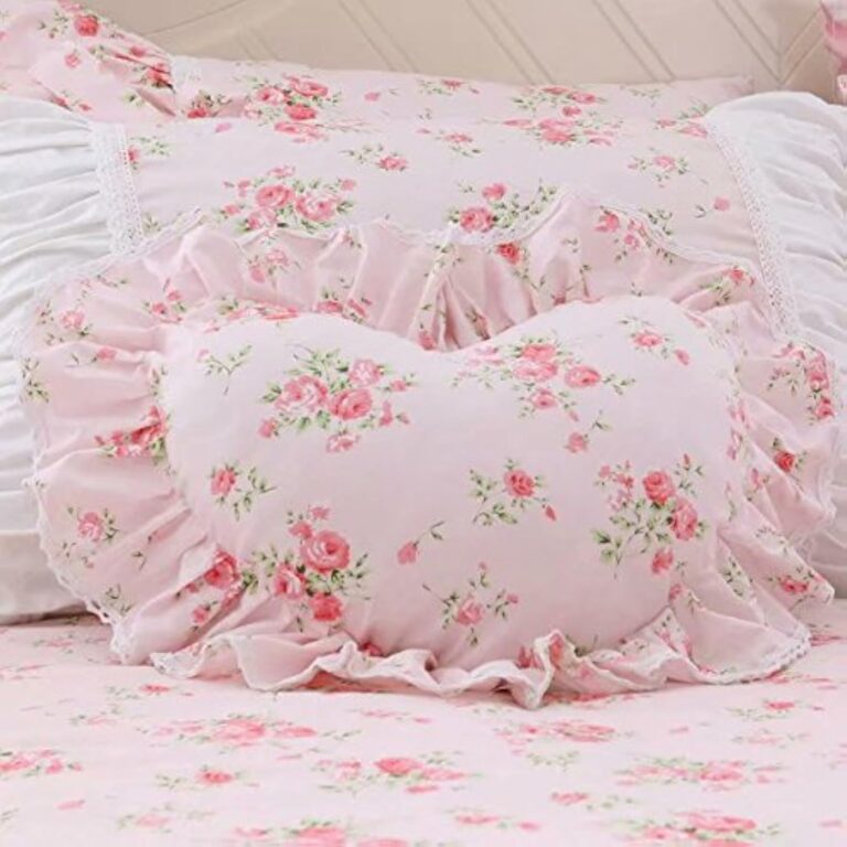 Pink heart-shaped throw pillow with lace ruffle trim and soft floral-inspired decorative design