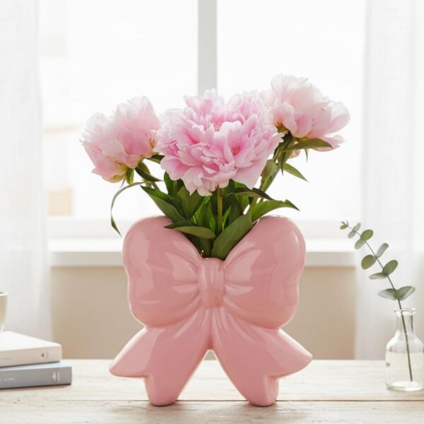 pink ceramic bow vase used as flower vase and makeup brush holder on vanity table