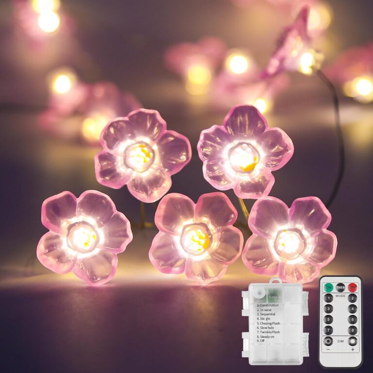 pink cherry blossom LED fairy string lights with warm glow decorating a cozy bedroom wall