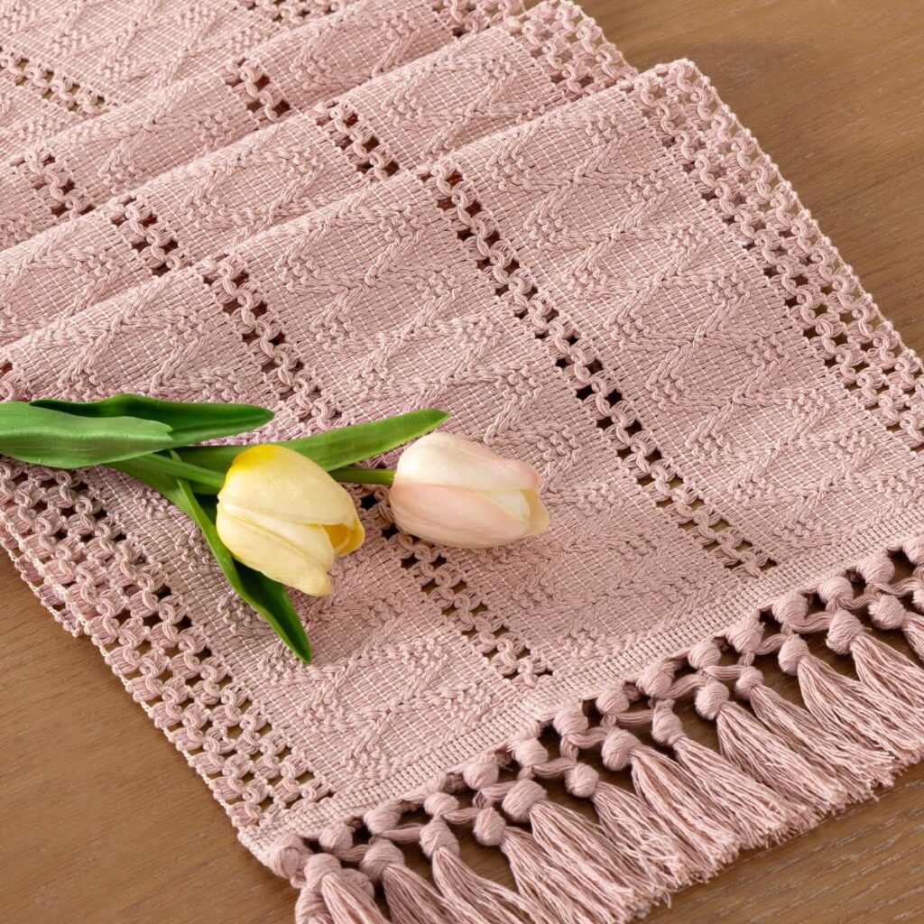 Pink boho macrame cotton table runner with woven geometric texture and fringe edges for farmhouse table decor