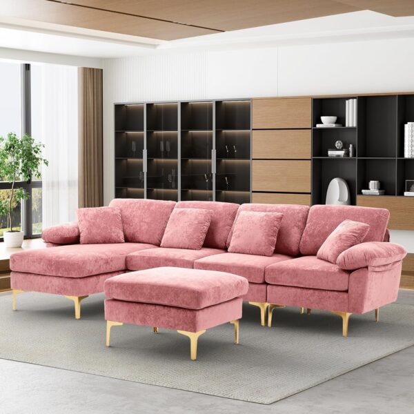 Large pink U-shaped velvet sectional sofa with chaise lounge, movable ottoman, gold-tone metal legs, and four matching throw pillows for modern living room décor.