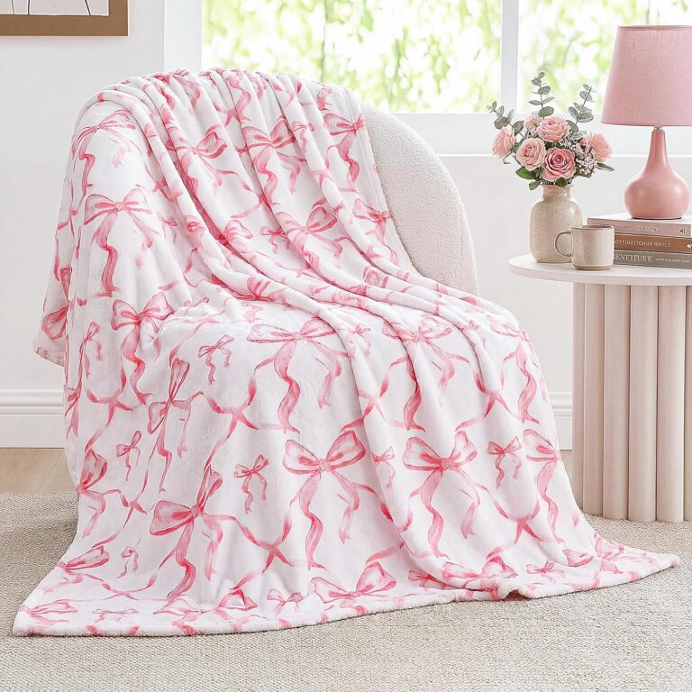 Pink flannel throw blanket with an all-over bow print, featuring a soft lightweight design for beds, sofas, dorm rooms, and coquette-inspired bedroom décor.