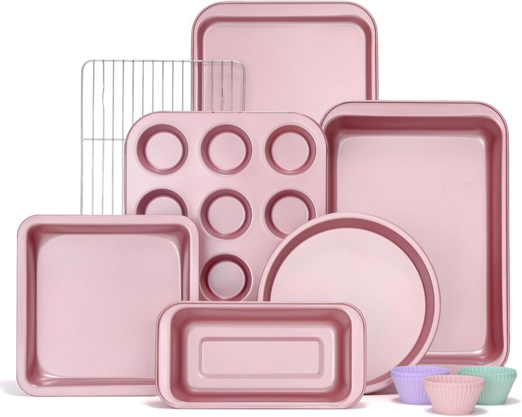 Pink 7-piece nonstick carbon steel bakeware set with a round cake pan, square cake pan, loaf pan, muffin pan, cookie sheet, roasting pan, and cooling rack for baking and roasting.