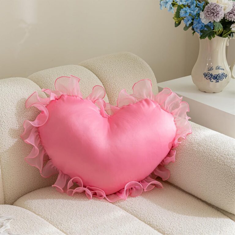 Pink heart-shaped decorative throw pillow with soft ruffle trim, plush polyester cover, PP cotton filling, and a removable machine-washable cover for beds, sofas, and chairs.