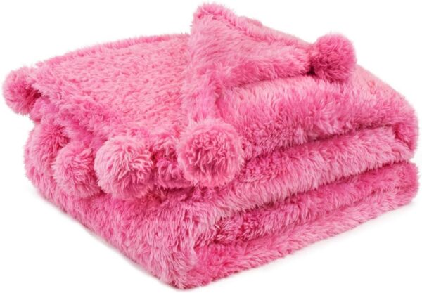 Hot pink microfiber sherpa throw blanket with decorative pom pom fringe, lightweight plush fleece blanket for couches, beds, and cozy indoor lounging.