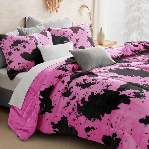 Petrichor Queen comforter set featuring a reversible pink and black cow print flannel fleece comforter with two matching pillow shams in a 3-piece Western bedding set