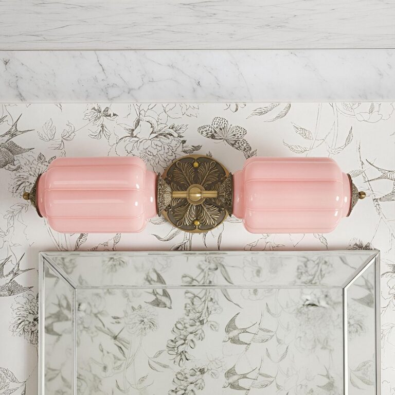 Vintage pink two-light wall sconce with hand-blown pink glass shades and a brass-finish metal base, designed for bathrooms, vanity mirrors, kitchens, bedrooms, and living spaces.