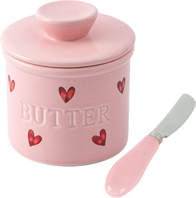 Pink ceramic French butter crock with heart pattern, water-seal lid, and matching butter spreader knife for keeping butter fresh and spreadable on the countertop.