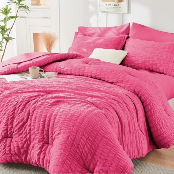 HYMOKEGE hot pink queen comforter set with textured seersucker bedding, matching pillow shams and pillowcases, fitted sheet, and flat sheet.