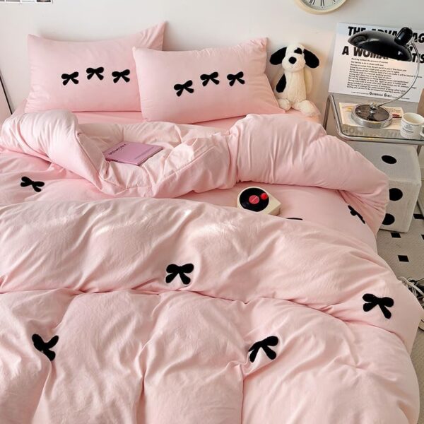 Tailor Shop pink twin comforter set featuring raised chenille bowknot embroidery in black, with a matching comforter, fitted sheet, flat sheet, and two pillowcases.